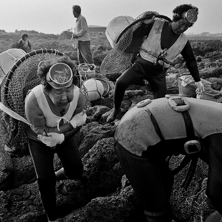 Elder women scuba divers gather their fishing gear